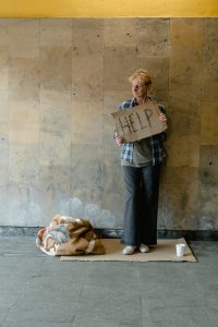 a woman holding cardboard says help